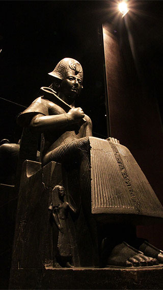 A statue sitting on throne at the Egyptian Museum lit by latest technology LEDs by Philips Lighting