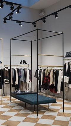 Merchandise hangs on racks at SuperTrash, illuminated by Philips retail lighting