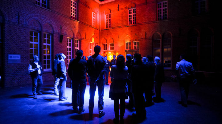 A big group of people is discussing outside of a nicely lit building at Turnhout, Belgium in a workshop organized by Philips