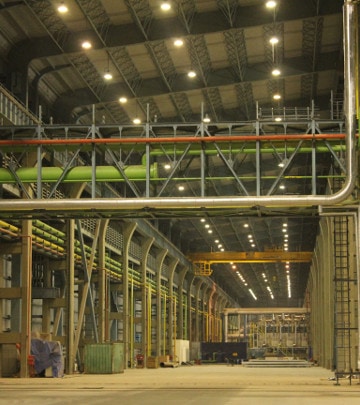 Highbay luminares installed across very high ceiling processing and manufacturing areas within the plant