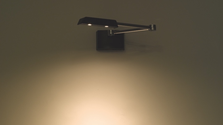 An adjustable lamp fixated at a wall