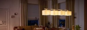 Modern LED pendant light with multiple fabric shades illuminates a cosy living room, showcasing energy-efficient and stylish home lighting solutions for ambient evening comfort.