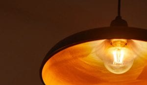 "Vintage-style LED filament bulb in pendant lamp, emitting warm golden glow, showcasing energy-efficient nostalgic lighting for cosy home ambiance."